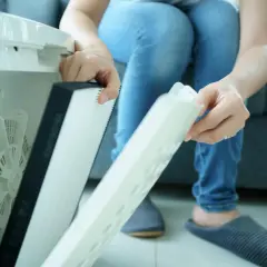 Osoba wymienia filtr w oczyszczaczu powietrza. Czy filtr HEPA można myć wodą? Nie, zazwyczaj nie.