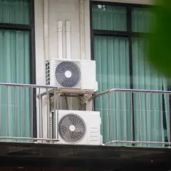 Dwa białe urządzenia klimatyzacyjne zamontowane na balkonie, zapewniające chłód w mieszkaniu.