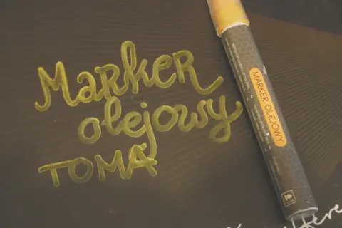 Marker olejowy do pisania po różnych powierzchniach, np. po metalu, szkle, plastiku. Napis "Marker olejowy" wykonany tym pisakiem.