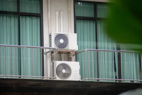 Dwa białe urządzenia klimatyzacyjne zamontowane na balkonie, zapewniające chłód w mieszkaniu.