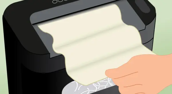 Ręka wkłada papier do niszczarki. Zastanawiasz się, olej do niszczarek czym zastąpić?