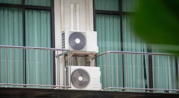 Dwa białe urządzenia klimatyzacyjne zamontowane na balkonie, zapewniające chłód w mieszkaniu.