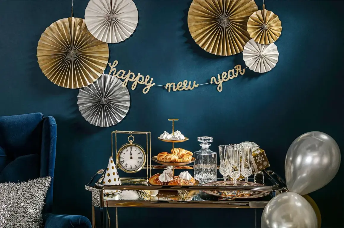 Złote i srebrne rozety, girlanda "happy new year" i eleganckie przekąski tworzą stylowe dekoracje sylwestrowe diy.