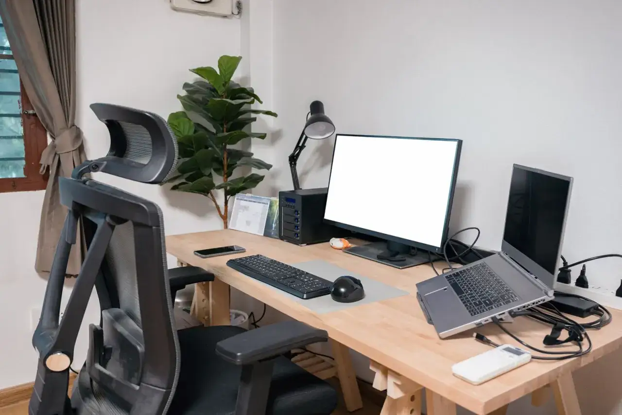 Ergonomiczne stanowisko pracy z komputerem, gdzie prawidłowe oświetlenie miejsca pracy przy komputerze zapewnia komfort i chroni wzrok.