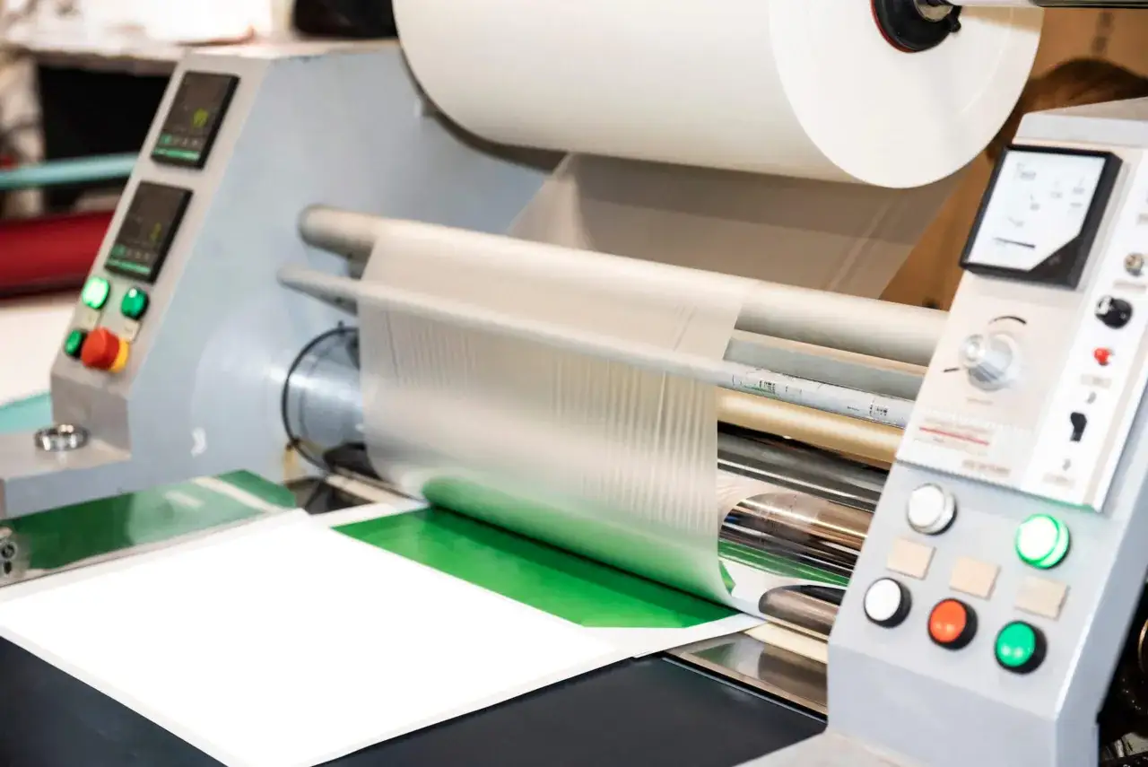 Profesjonalny laminator w akcji, zabezpieczający dokumenty folią. To urządzenie, które chroni i uszlachetnia wydruki.