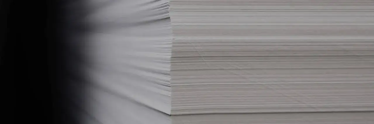 Stos papieru, z lewej strony zaciemniony, z prawej widoczne liczne cienkie kartki. Ile kartek ma ryza papieru?