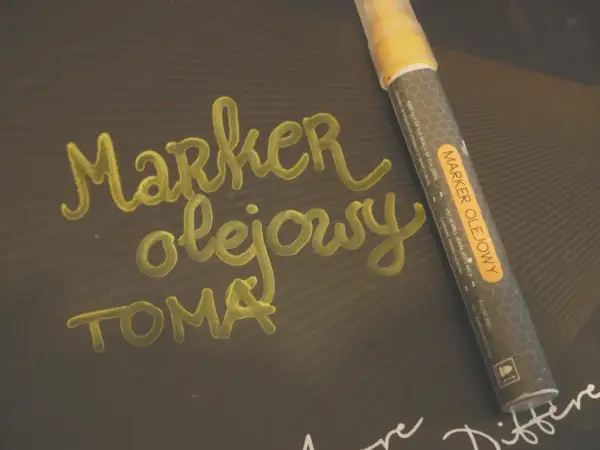 Marker olejowy do pisania po różnych powierzchniach, np. po metalu, szkle, plastiku. Napis "Marker olejowy" wykonany tym pisakiem.