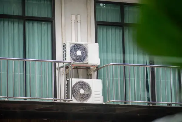 Dwa białe urządzenia klimatyzacyjne zamontowane na balkonie, zapewniające chłód w mieszkaniu.